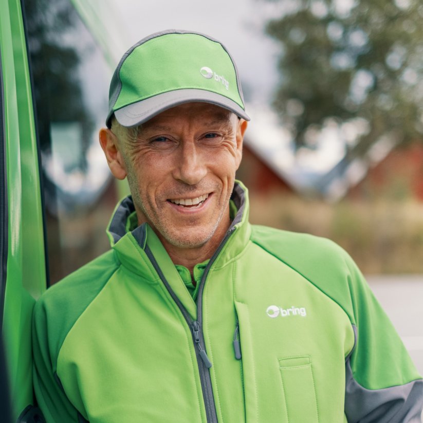 Smilende mannlig Bring-sjåfør.