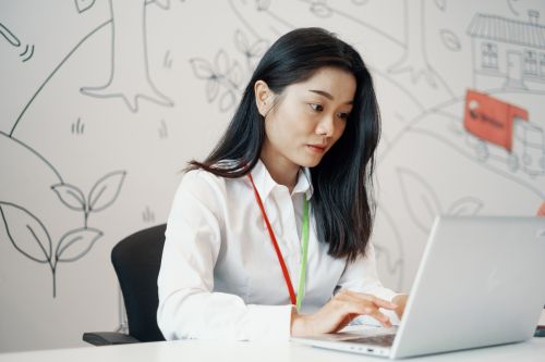 Kvinnelig ansatt i Posten Norge AS jobber på PC