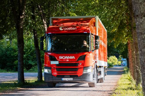 Lastebil fra Posten kjører på grusvei