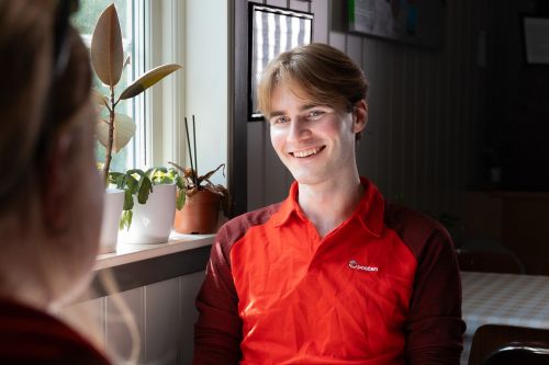 Ung sjåfør fra Posten i samtale med en kunde