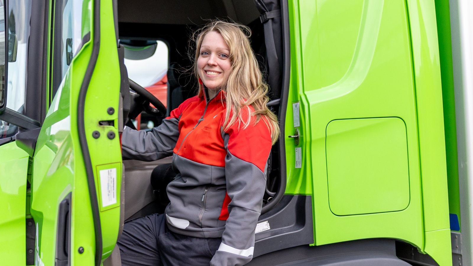 Marion fra Posten Bring står ved en Bring-lastebil