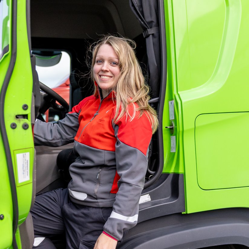 Marion fra Posten Bring står ved en Bring-lastebil