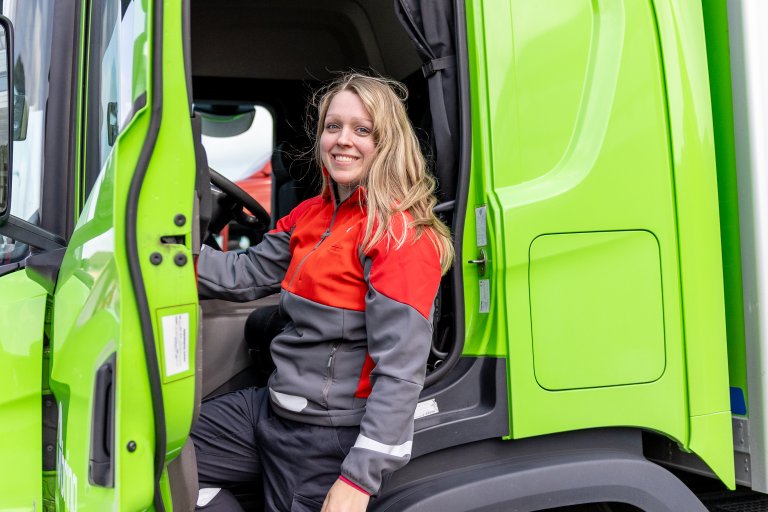 Marion fra Posten Bring står ved en Bring-lastebil