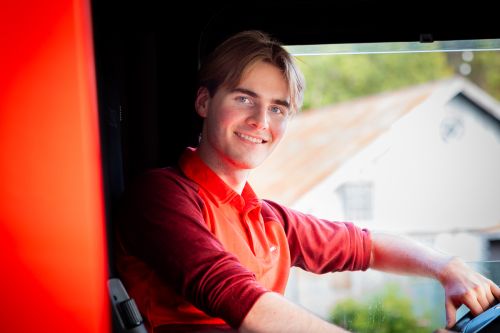 Ung yrkessjåfør fra Posten sitter bak ratten i lastebilen