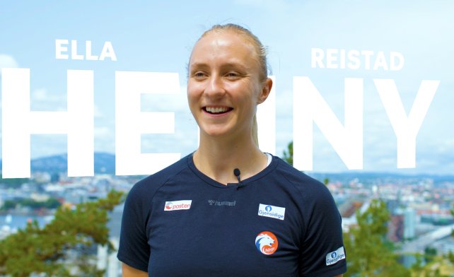 Henny Reistad står på en høyde med Oslo i bakgrunnen